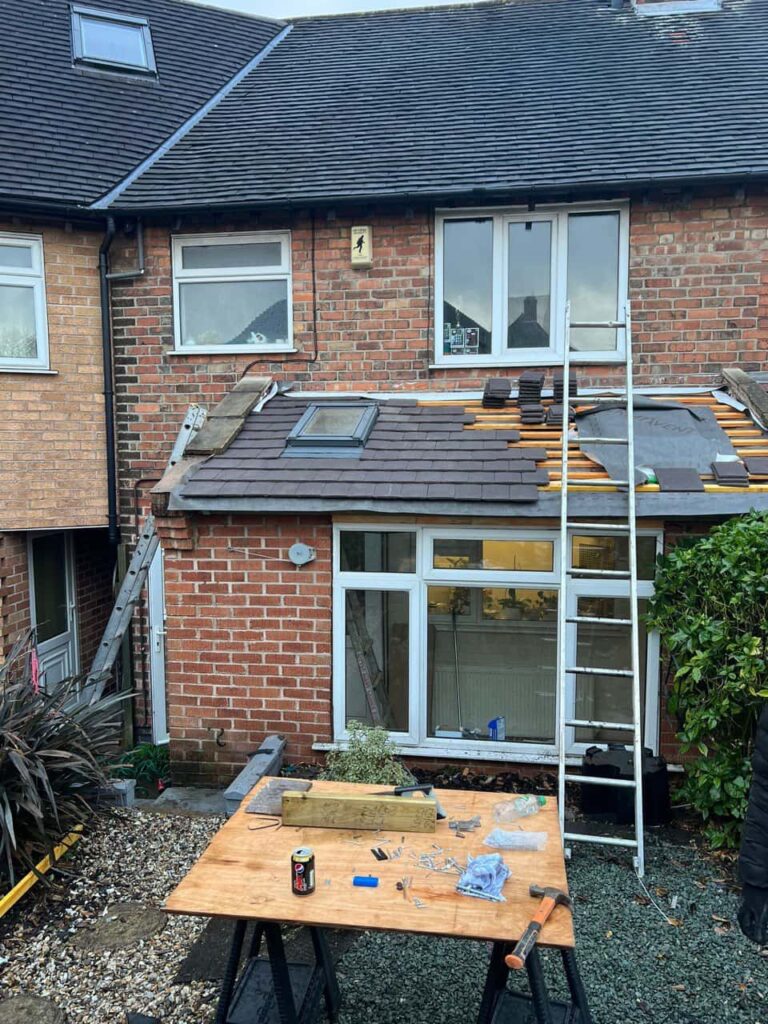 This is a photo of a roof extension that is having new roof tiles installed. This is a photo taken from the roof ridge looking down a tiled pitched roof on to a flat roof. Works carried out by TRP Roofing Hessle
